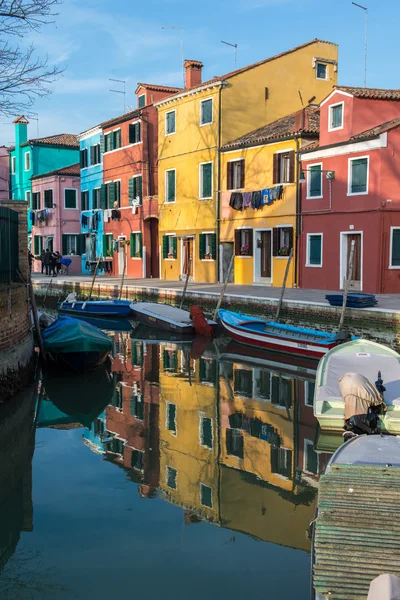 Bunt bemalte Häuser mit Spiegelungen im Wasser auf Burano und Boote im Kanal — Stockfoto