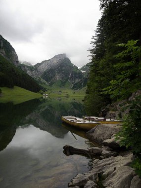 Alpstein 'deki Seealpsee Alp Dağları' ndaki Alp Gölü 'nde sarı kürek teknesi Appenzell Innerrhoden İsviçre