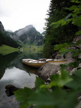 Alpstein 'deki Seealpsee Alp Dağları' ndaki Alp Gölü 'nde sarı kürek teknesi Appenzell Innerrhoden İsviçre