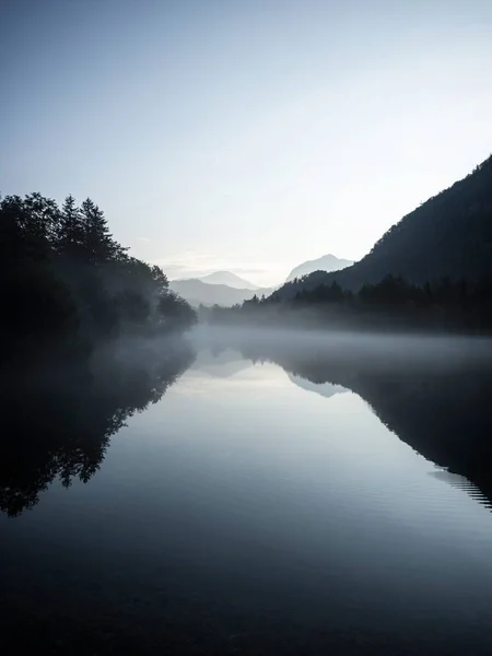 Niedrige Wolken nebeln neblige Stimmung Reflexion des Baumwaldes Tal im Bluntausee Golling Salzburg Österreich Alpenberge — Stockfoto