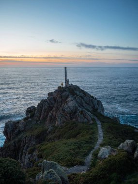 Sarı ceketli adam metal yapı bakış açısı Cabo Prior deniz feneri kayalık kıyısı kıyısı Galiçya İspanya