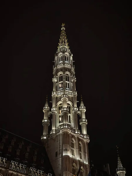 Illuminated spire tower of medieval gothic Brussels City Town Hall grand place grote markt square in night sky Belgium — Stock Photo, Image