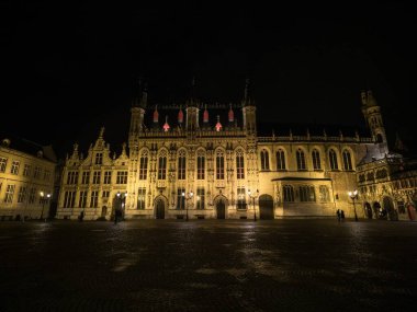 Belçika 'nın Burg Meydanı' ndaki Bruges Belediye Binası 'nın aydınlık cephe mimarisinin panoramik görüntüsü