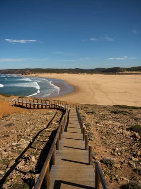 Carrapateira Sahili Algarve Portekiz 'de Praia da Bordeira' da terk edilmiş sörf plajlarına giden ahşap patika yolu.