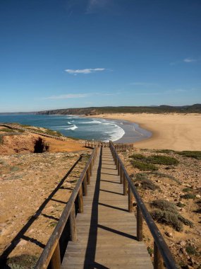 Carrapateira Sahili Algarve Portekiz 'de Praia da Bordeira' da terk edilmiş sörf plajlarına giden ahşap patika yolu.