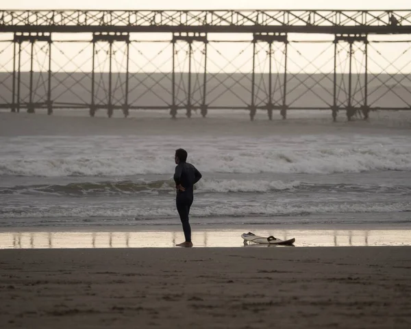 Surfista de pie en Playa Pimentel playa de arena con Muelle muelle en el fondo Chiclayo Lambayeque Perú América del Sur — Foto de Stock