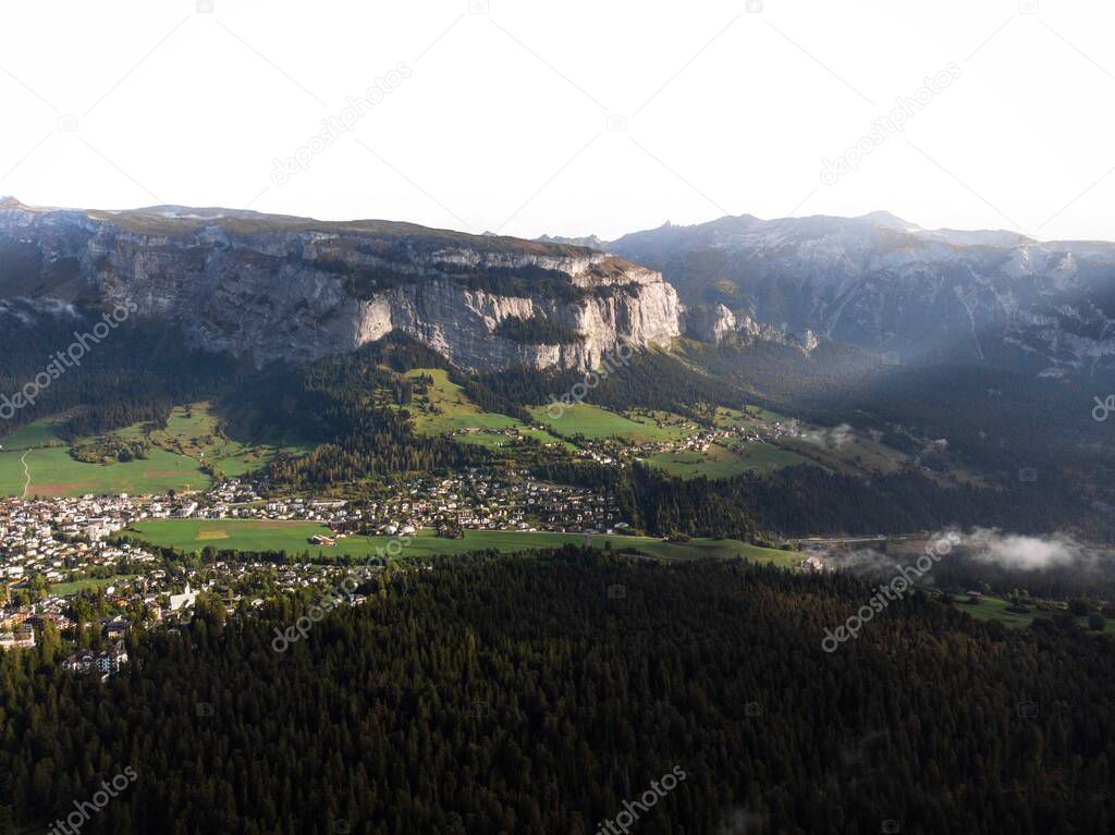 View towards swiss alpine mountain village town Flims Laax from Caumasee in Grisons Graubunden Switzerland in Europe