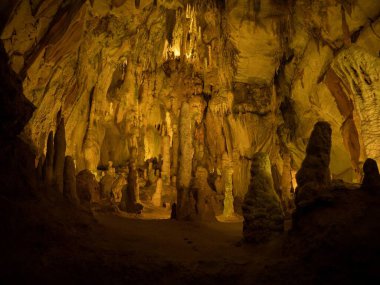 Illuminated lit lights stalagmites stalactites limestone show cave cavern Grutas da Moeda in Batalha Leiria Portugal clipart