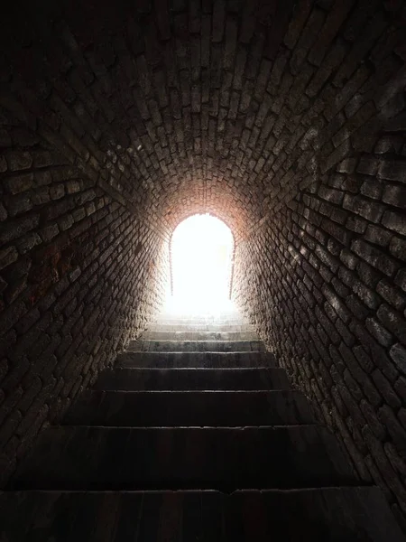 Light at the end of the tunnel cave entrance exit staircase in medieval castle hill Schlossberg in Graz Styria Austria — Stock Photo, Image