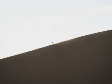 Huacachina Ica Peru 'nun kuru kum tepeciklerine tırmanan tek bir kişinin manzarası
