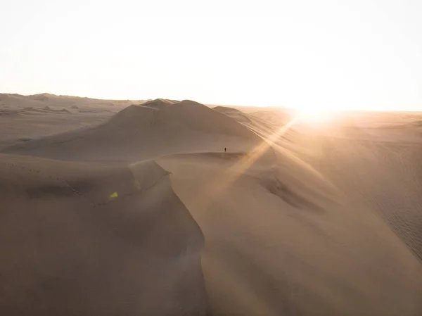 Ansichtkaart panorama zonsondergang zicht op geïsoleerde eenzame man persoon droge zandduinen woestijn van Huacachina Ica Peru — Stockfoto