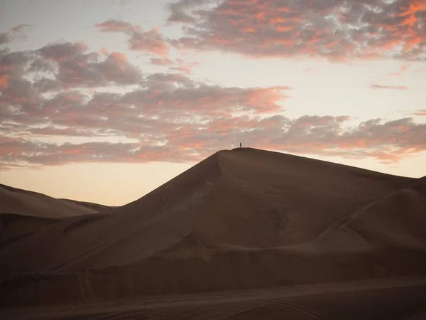 Panorama do cartão postal aéreo vista do pôr-do-sol isolado solitário único homem pessoa no deserto de dunas de areia seca de Huacachina Ica Peru — Fotografia de Stock