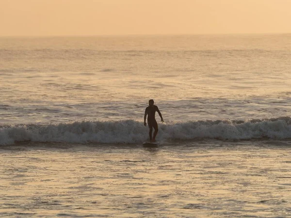 Vista panorámica al atardecer del surfista montando una ola en la playa de Huanchaco Océano Pacífico Trujillo Perú Sudamérica — Foto de Stock