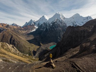 Sarı ceketli erkek yürüyüşçü, Cordillera Huayhuash Circuash ve San Antonio dağı Laguna Jurau Huanuco Peru 'yu geçiyor.