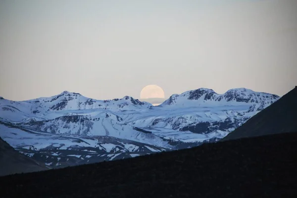 Luna llena que sube sobre picos nevados de la montaña de hielo cerca de Solheimasandur DC3 avión naufragio arena volcánica negra Islandia — Foto de Stock