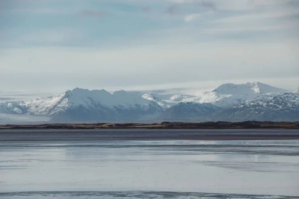 Vista panorámica de la cordillera cubierta cubierta de nieve naturaleza invierno paisaje en el agua del océano lago en Islandia Europa — Foto de Stock