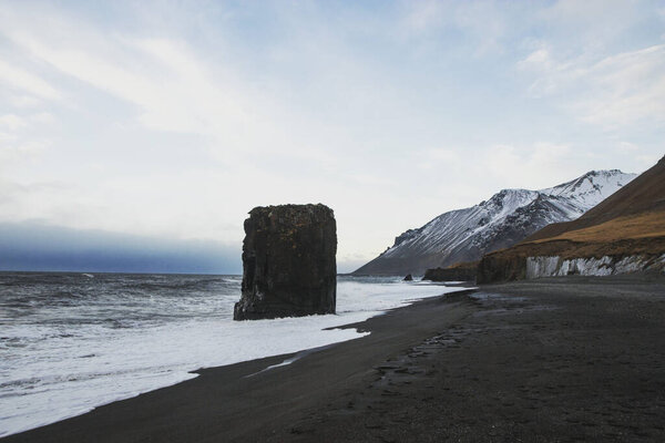 Panorama of Laekjavik beach rock formation sea stack black sand atlantic ocean coast tower east fjords Iceland Europe