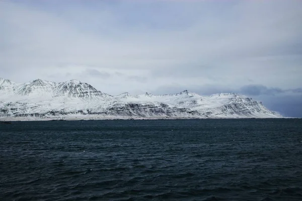 Panorámás kilátás hó fedett hegység fjord természet téli táj tó óceán víz Izlandon Európa — Stock Fotó