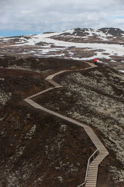 Turista de pie en escaleras de madera escalones del borde del cráter de lava del volcán Grabrok en Borgarfjordur Islandia Occidental — Foto de Stock