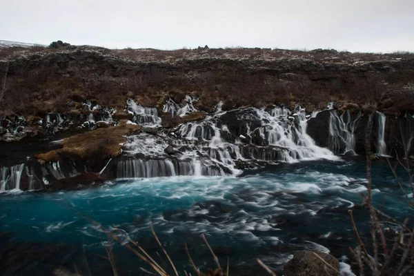 Πανόραμα μεγάλης έκθεσης του τυρκουάζ βαθύ μπλε καταρράκτη Hraunfossar καταρράκτη Hvita River στο Husafell Reykholt της Ισλανδίας — Φωτογραφία Αρχείου