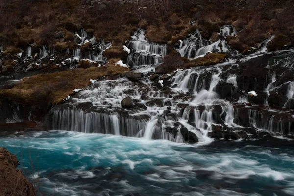 Panorama lång exponering av turkos djupblå Hraunfossar vattenfall kaskad Hvita floden i Husafell Reykholt Island — Stockfoto