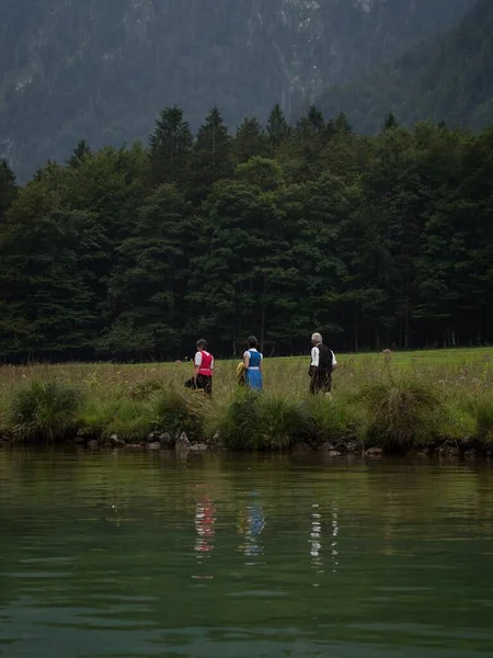 伝統的なバイエルンの服の人々は、湖Konigssee Berchtesgadenバイエルンドイツでトラット・ディンドル・レーダーホーゼン — ストック写真