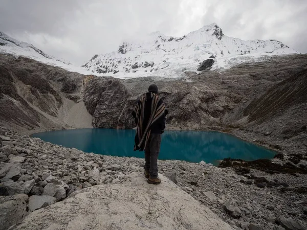 Senderista en tradicional capa de poncho indígena en el lago de montaña andino Laguna 69 Cordillera Blanca Huaraz Ancash Perú —  Fotos de Stock