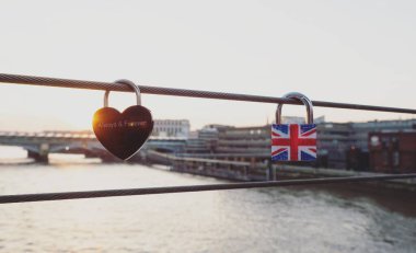 Kırmızı kalp şeklindeki aşk kilidi daima bayrak asma kilidini simgeler Milenyum köprüsü Thames Londra İngiltere İngiltere