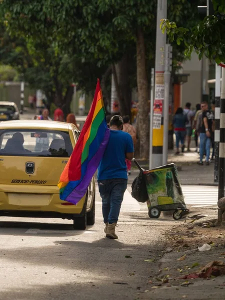 Hombre caminando con bandera arco iris en marcha LGBTQI desfile gay orgullo celebración evento a través de las calles de Medellín Colombia —  Fotos de Stock