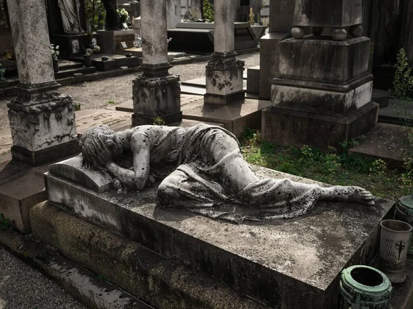 Old ancient historic grave tomb stone sculpture memorial at Cimitero Monumentale graveyard in Milan Lombardy Italy