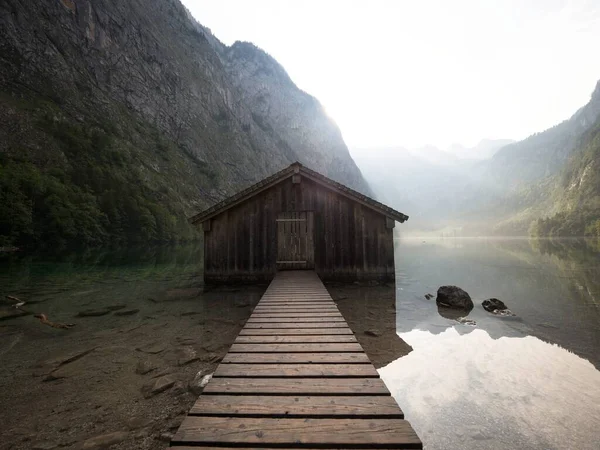 Panorama reflection of old wooden boat house shed alpine mountain lake Obersee Koenigssee Berchtesgaden Bavaria Germany — Stock Photo, Image