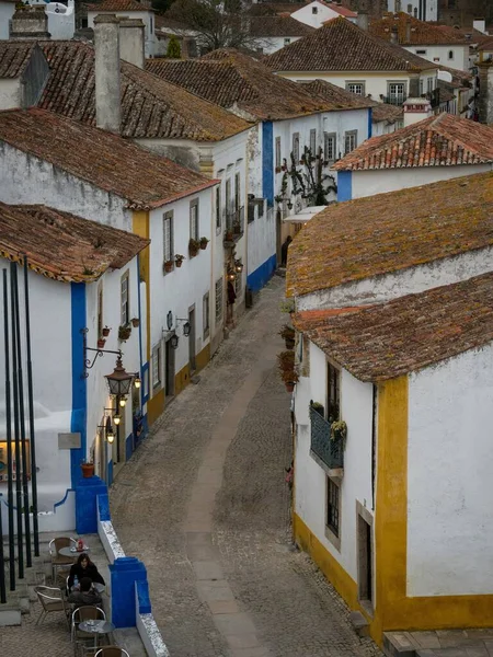 Panorama vista de las antiguas paredes blancas históricas casas edificios estrecha callejuela adoquinada calle callejón en Obidos Portugal — Foto de Stock