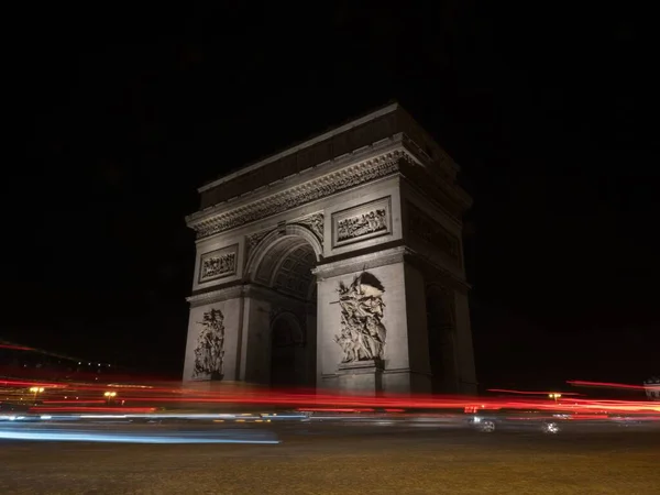 Longa exposição noite panorama trilhos semáforos semáforos no Arco do Triunfo monumento Etoile Campos Elísios Paris França — Fotografia de Stock