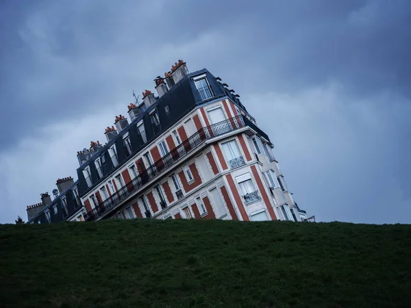 Panorama vista ilusión óptica del antiguo edificio histórico de la casa que se hunde en la colina verde de la hierba Montmartre París Francia Europa —  Fotos de Stock