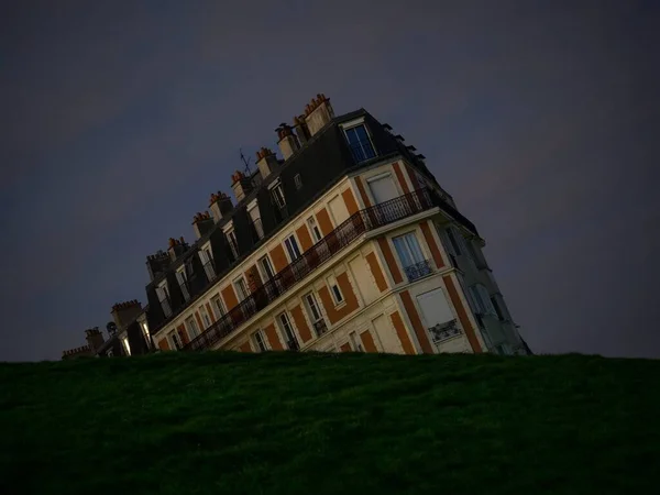 Optical illusion night panorama of historic old sinking house building at green grass hill Montmartre Paris Francia —  Fotos de Stock