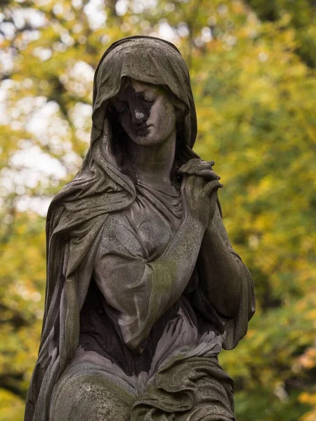 Female statue woman sculpture folding hand prayer mourning grief graveyard tombstone Pere Lachaise cemetery Paris France