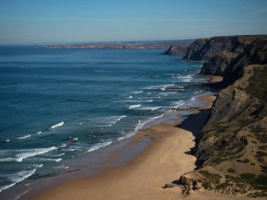 Gökyüzü insansız hava aracı manzarası Praia da Cordoama plaj atlantik okyanusu Vila do Bispo Sagres, Algarve Portekiz Avrupa 'ya çarpan kayalık kıyı dalgaları.