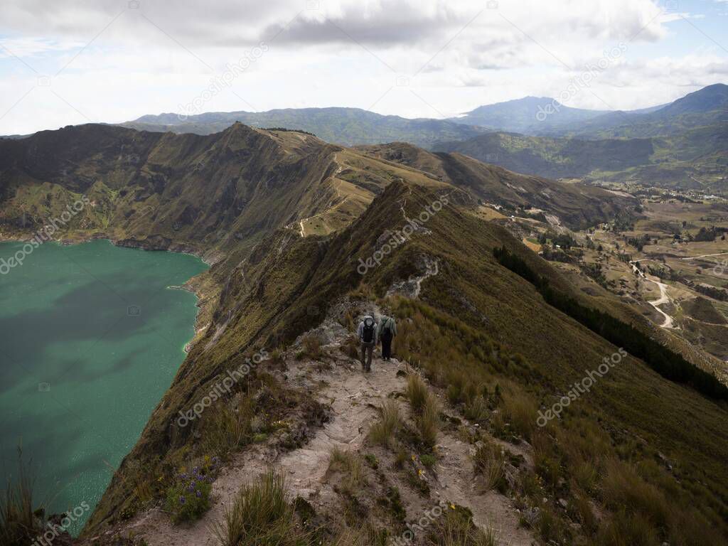 Hikers walking on andean volcano caldera crater lake Quilotoa rim ridge loop in Pujili Cotopaxi Ecuador andes South America