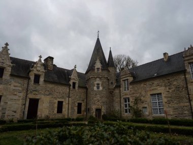 Taş kaya cephesi, Rochefort en Terre 'deki binalara ev sahipliği yapıyor. Eski, tarihi ortaçağ ortaçağ kasabası Questembert Vannes Brittany Fransa Avrupa' sındaki köy.