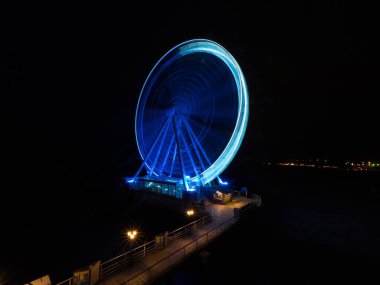 Gece vakti aydınlatmalı mavi gökyüzü manzaralı dönme dolap deniz kenti Scheveningen 'in iskelesinde Lahey Hollanda Avrupa