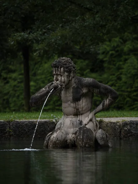 Closeup portrait of a male figure statue water fountain in Schloss Hellbrunn castle gardens near Salzburg Austria alps Europe