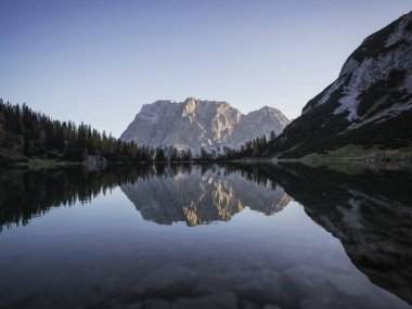 Ehrwald 'daki Seebensee saydam alp gölünde Zugspitze dağ kitlesinin gündoğumu ayna yansıması manzarası Avrupa' yı kaplıyor