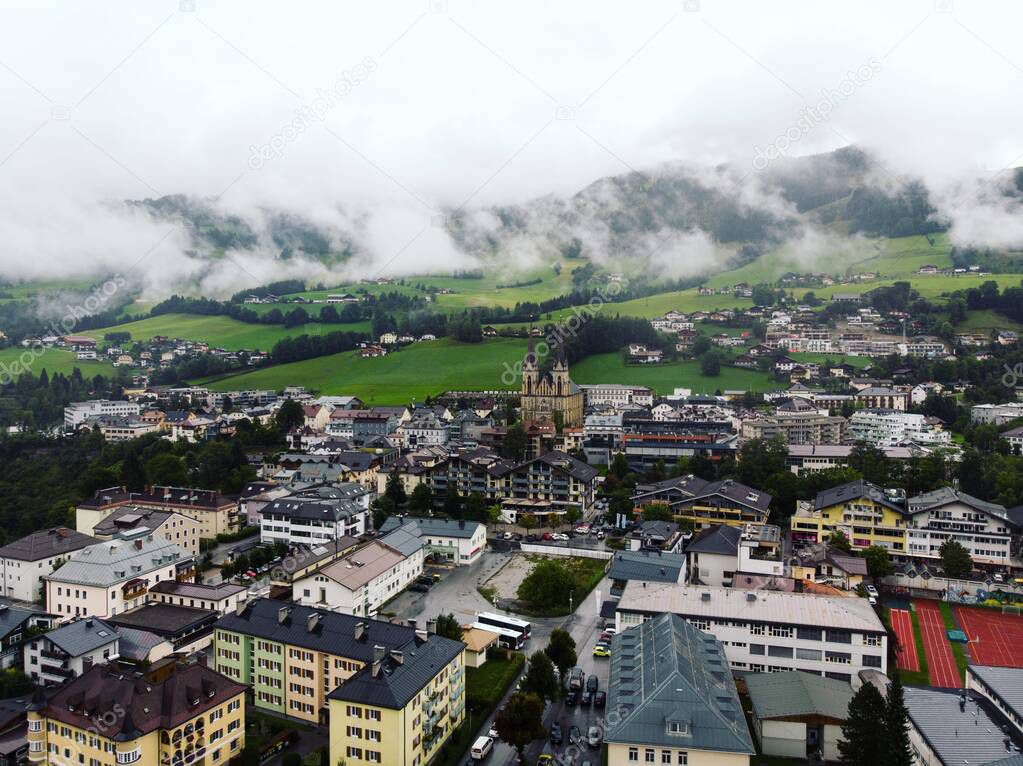 Aerial panorama view of alpine mountain town village city St. Johann im Pongau with cathedral dome in Salzburg Austria alps Europe