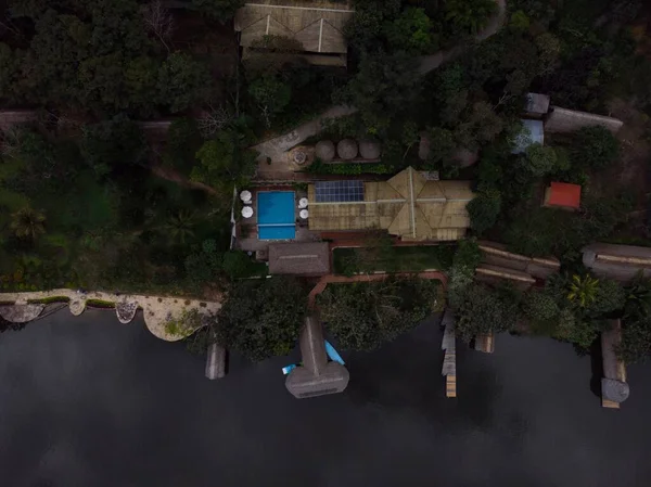 Aerial panorama view of Amazon tropical rainforest exotic lush jungle eco lodge hotel wooden cabin stilt hut at river lake in South America