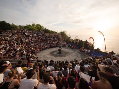 Okyanus kayalığı manzaralı Kecak ateş dansı gösterisi geleneksel ruhani kültür Ramayana törenini Endonezya 'nın güneydoğu Asya kentindeki Uluwatu Tapınağı Bali' de gösteriyor.