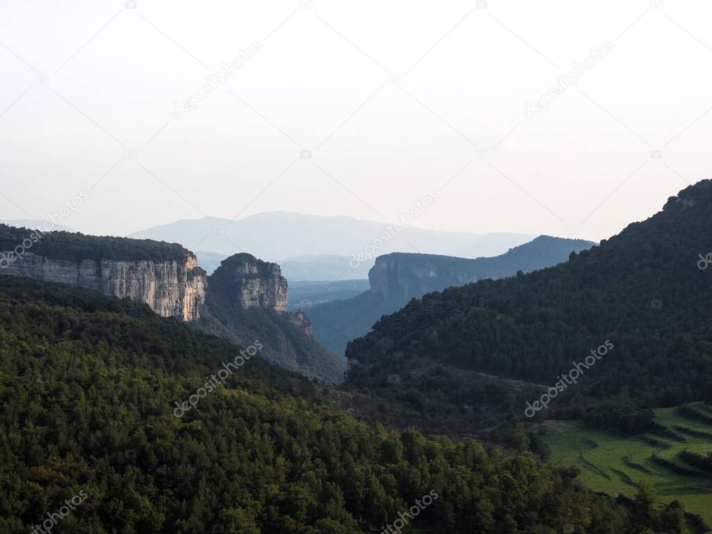 Panorama view of stone rock cliff gorge canyon with green grass meadow fields near Tavertet Osona Barcelona Catalonia Spain Pyrenees mountains Europe