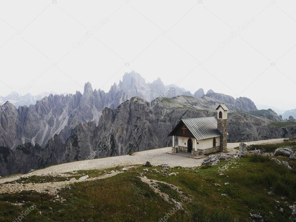 Alpine panorama of Cappella degli Alpini mountain chapel in front of Cadini di Misurina range group from Tre Cime di Lavaredo peak summit in Sexten Dolomites, Belluno South Tyrol Italy alps Europe