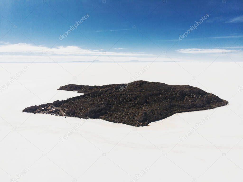 Aerial panorama view of isolated cactus island Incahuasi Inkawasi on white salt flat lake Salar de Uyuni in Potosi Bolivia South America