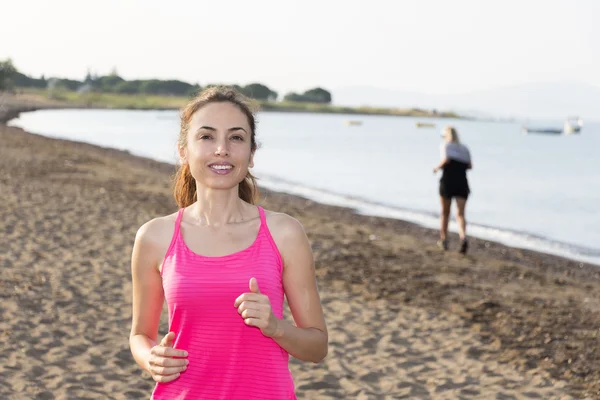 Aktive Frau joggt am Strand — Stockfoto