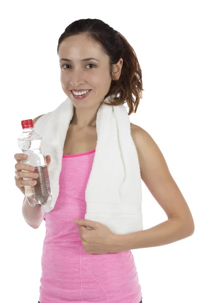 Passar sportiga kvinnan innehar en vattenflaska med en handduk runt henne Royaltyfria Stockbilder